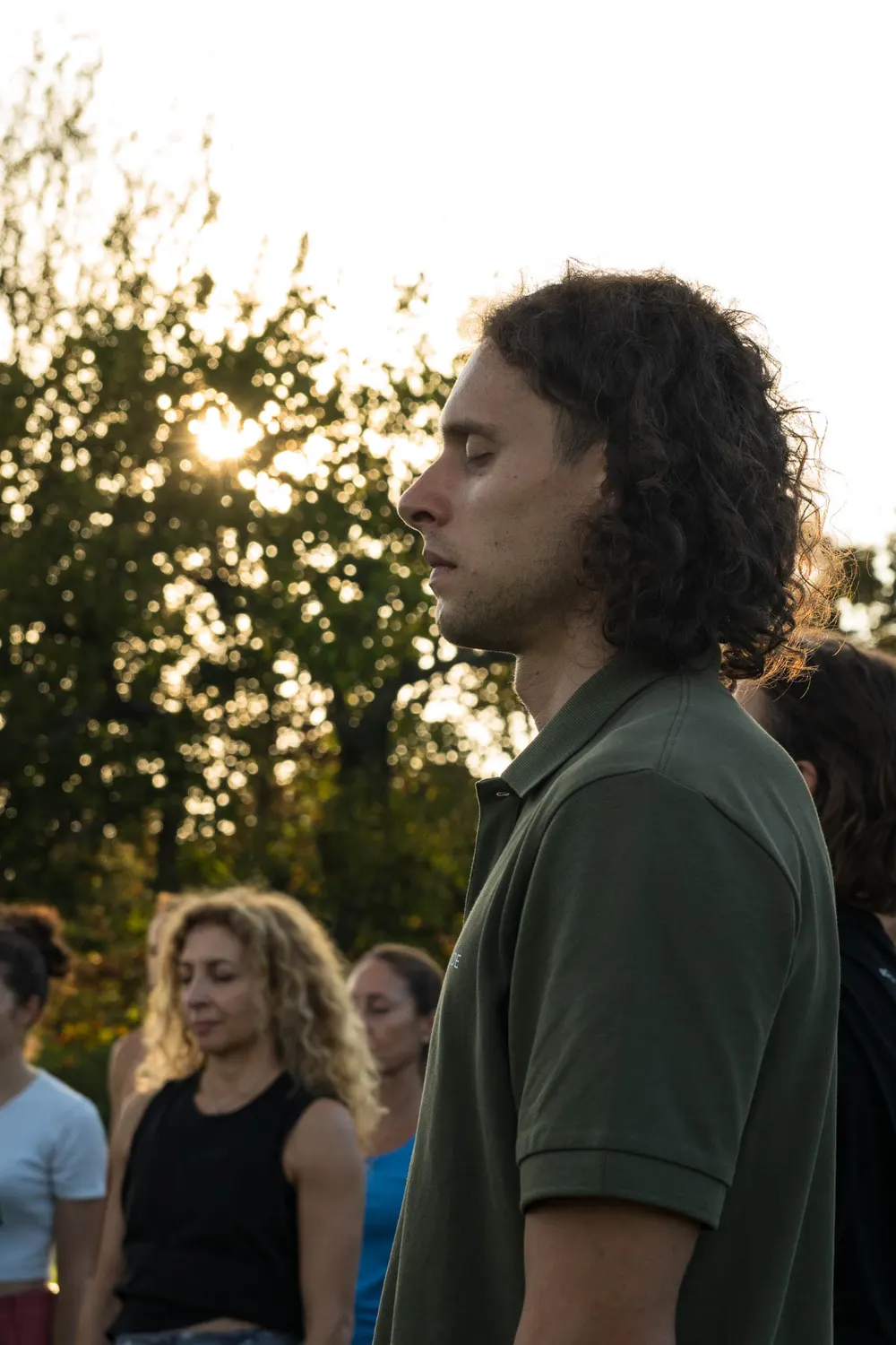 Coach del movimento osserva il gruppo durante una sessione pratica al tramonto