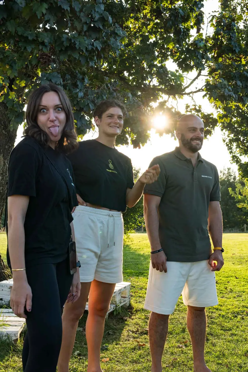 Tre partecipanti della formazione Moveinside che scherzano insieme all'aperto al tramonto