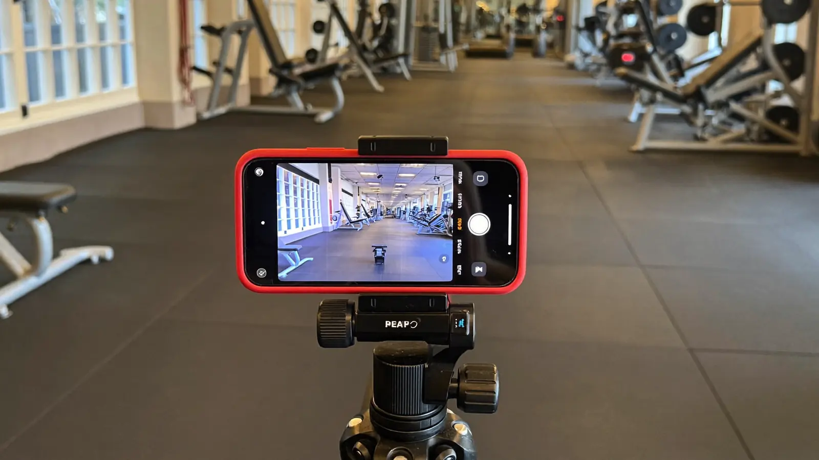 Smartphone su treppiede pronto a registrare in una palestra vuota