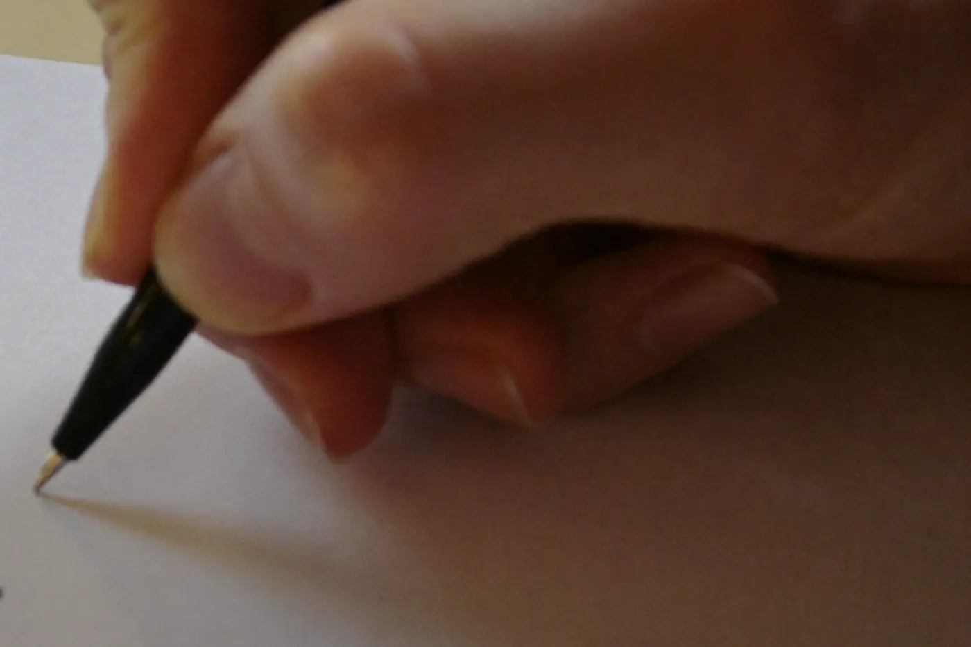 Dettaglio ravvicinato di un modulo cartaceo compilato a mano appoggiato su un piano di legno