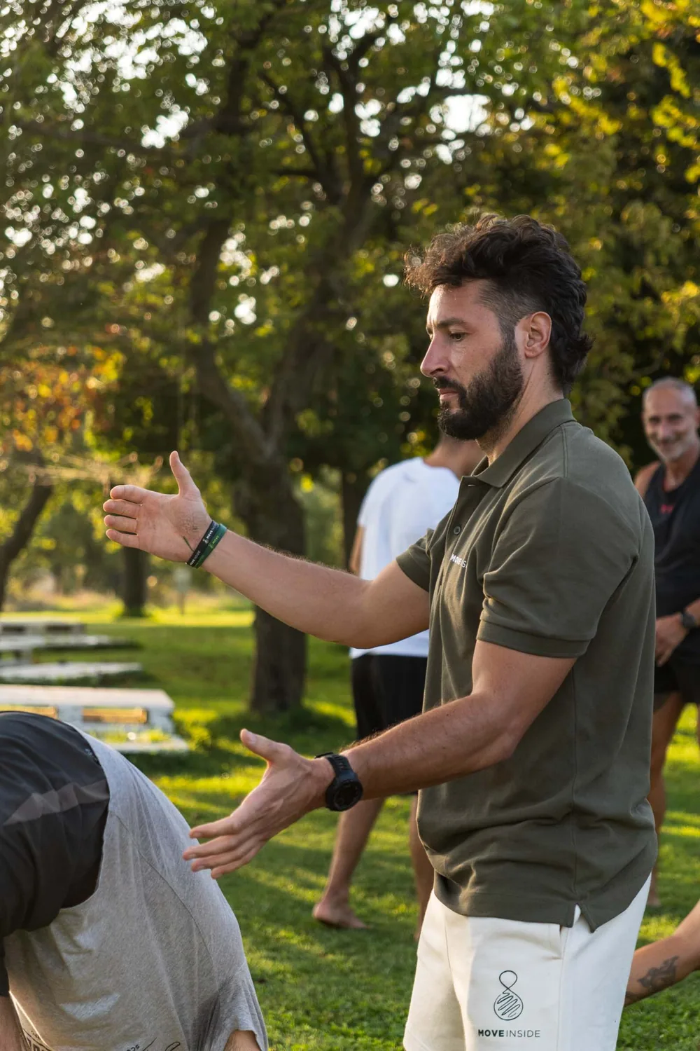 Coach Moveinside che guida con le mani una studentessa in un esercizio uno a uno sul prato