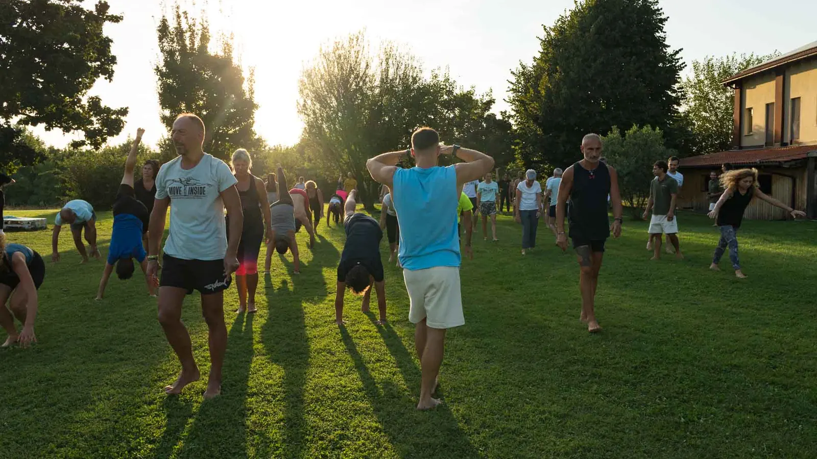 Gruppo di studenti Moveinside si allena su un prato al tramonto durante un intensivo di formazione